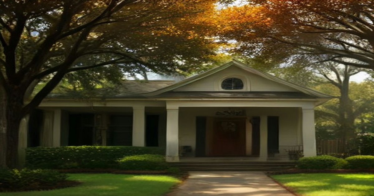 Pensacola-style craftsman home under live oaks with orange fall leaves, illustrating living in Pensacola during fall events season